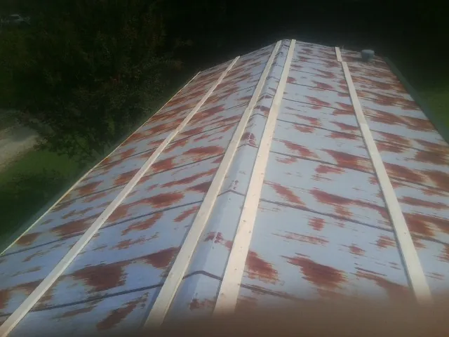 Rusted metal roof panels with new wood purlins before replacement — Storm Damage Roof Repair in Watsontown by Roofing Brothers