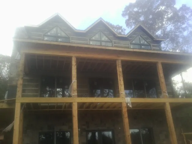 Dormers and porch framing on a large log home under construction — Roof Coating work by our crew in Watsontown